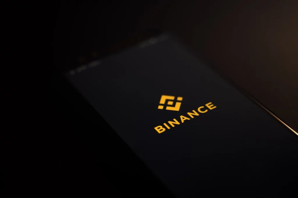 black background with mobile phone and Binance